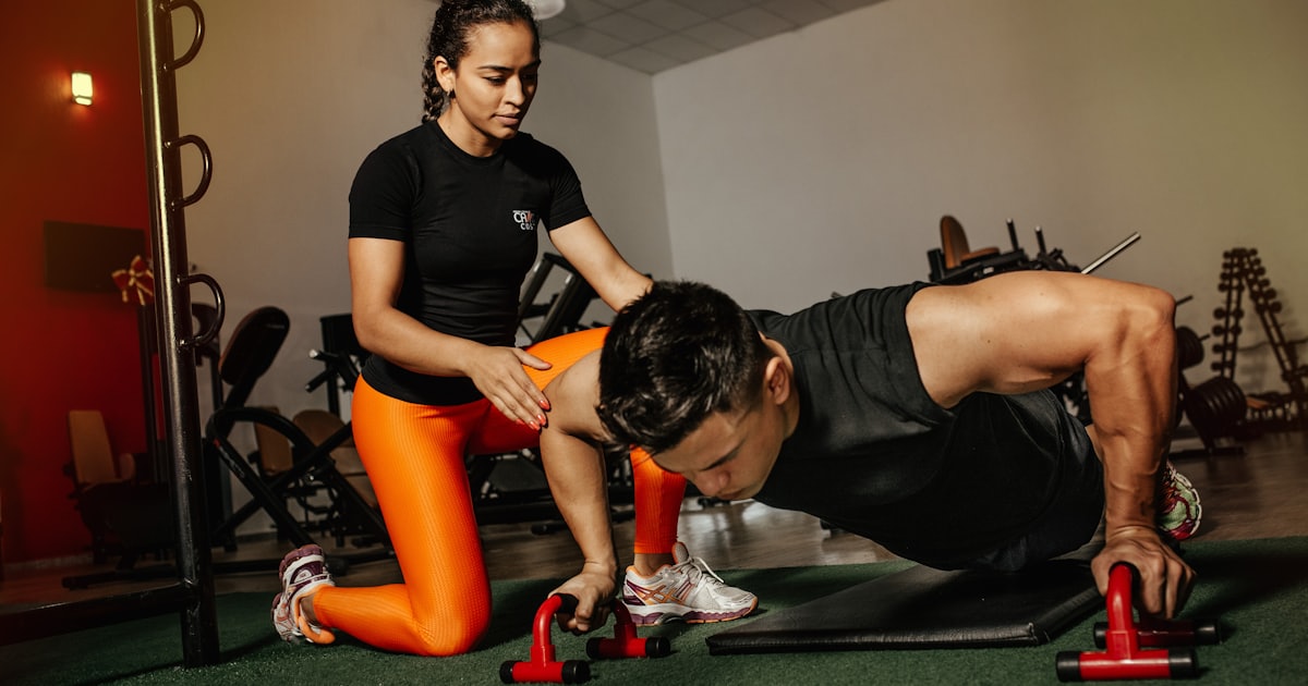 Profissional orientando uma pessoa durante um exercício, representando acompanhamento