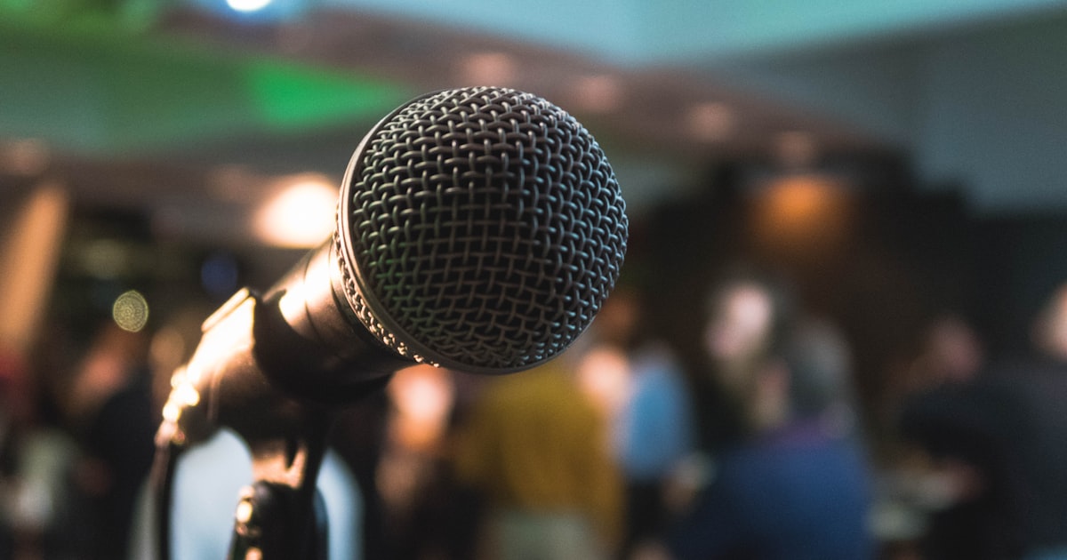 Microfone em um evento, representando palestras e ações locais