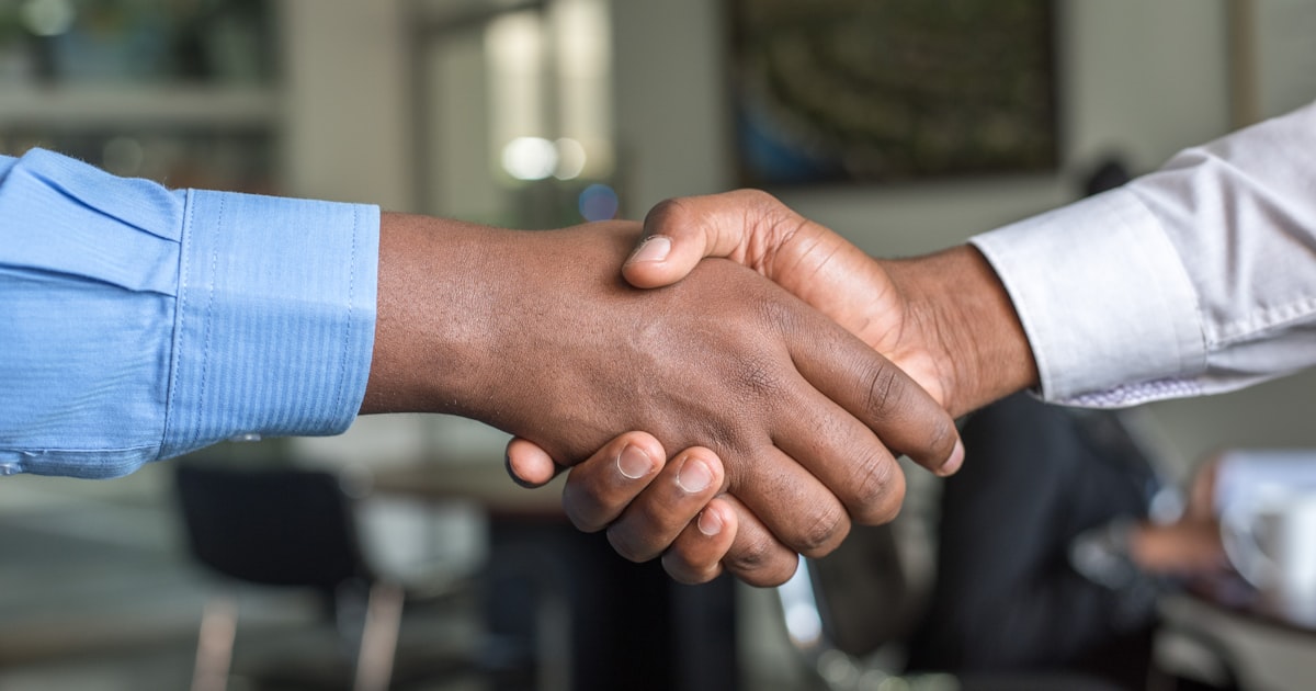 Aperto de mãos entre dois profissionais, simbolizando networking e confiança